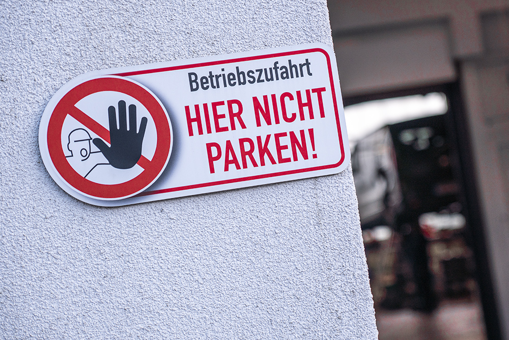 Warnschild "nicht parken" vor einer Toreinfahrt